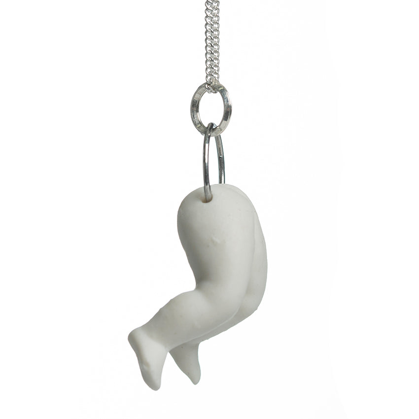 Hollow white porcelain doll's legs pendant produced by Martha Todd, one of the exhibiting artists of The Uncanny: A Centenary.