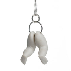 Hollow white porcelain doll's legs pendant produced by Martha Todd, one of the exhibiting artists of The Uncanny: A Centenary.