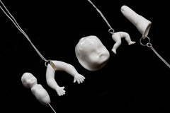 All the porcelain jewellery produced by Martha Todd, for the Uncanny exhibition at the Freud Museum. White porcelain legs, arms, dolls heads and a finger on a black background,