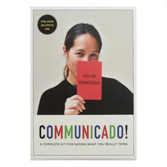 Front of the box for a game called Communicado, with a girl holding up a card saying "you're dismissed!"